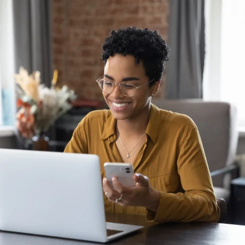 Woman using laptop and phone