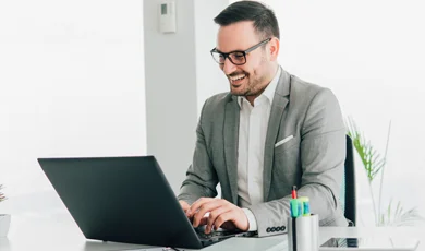 Man Smiling Working on Laptop