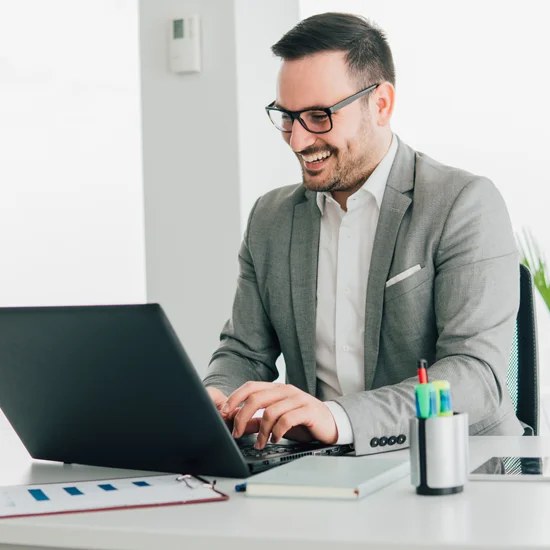 Man Smiling Working on Laptop