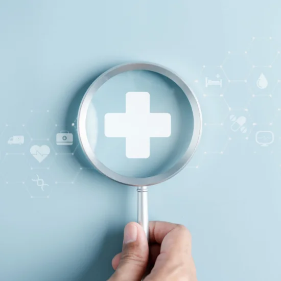A human hand holding magnifying glass hovering over general health insurance agency logo