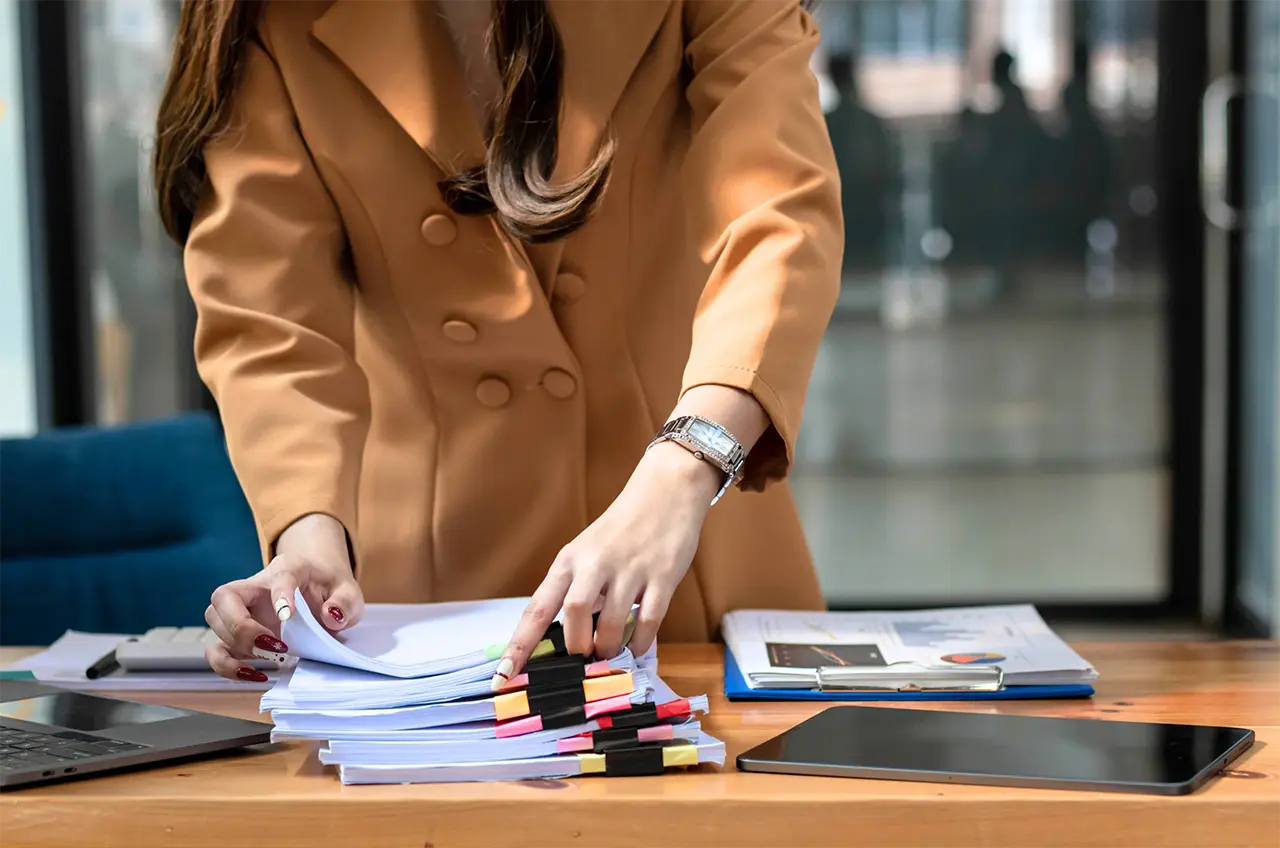 Business woman sorting through stacks of reports