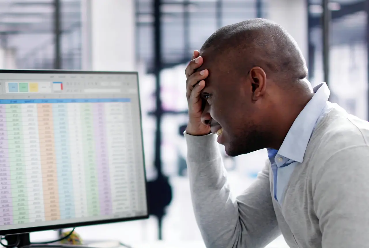 Stop manual processes from draining your bottom line Frustrated man working on his computer