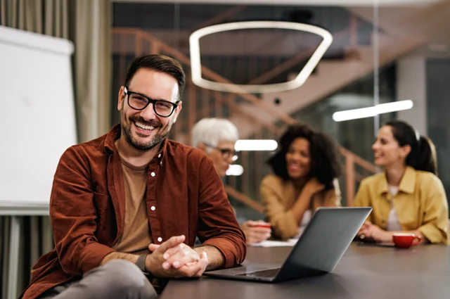 Colleagues in conference room, one smiling Colleagues in conference room, one smiling